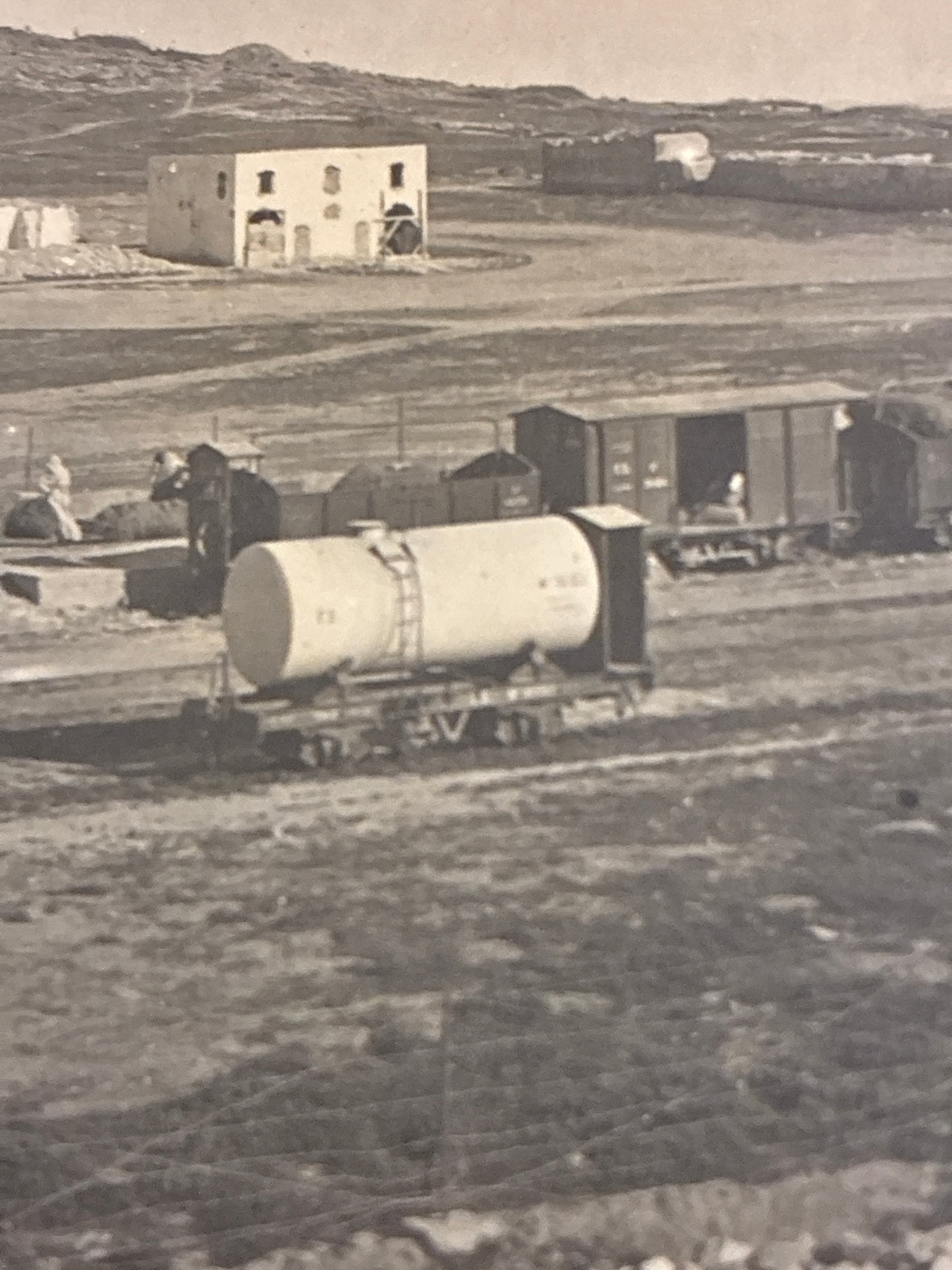 Cartolina postale italiana d'epoca coloniale con veduta dello scalo ferroviario e dei vagoni cisterna della ferrovia di Azizia in Libia