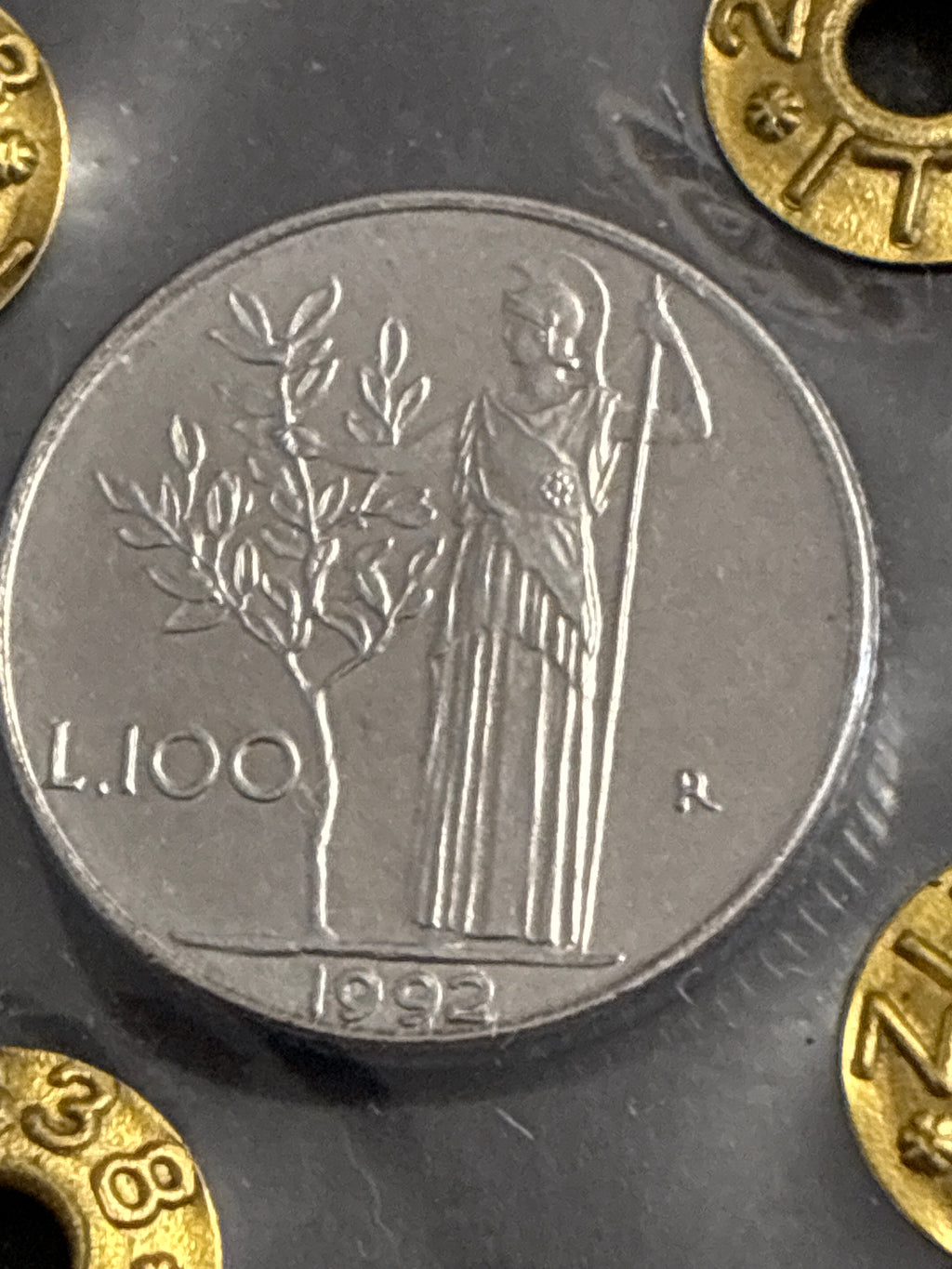 Moneta da 100 Lire 1992 Periziata Zilli - Errore di Conio: I Nr 99 Chiusi e Riga di Metallo in Rilievo Obliqua FDC