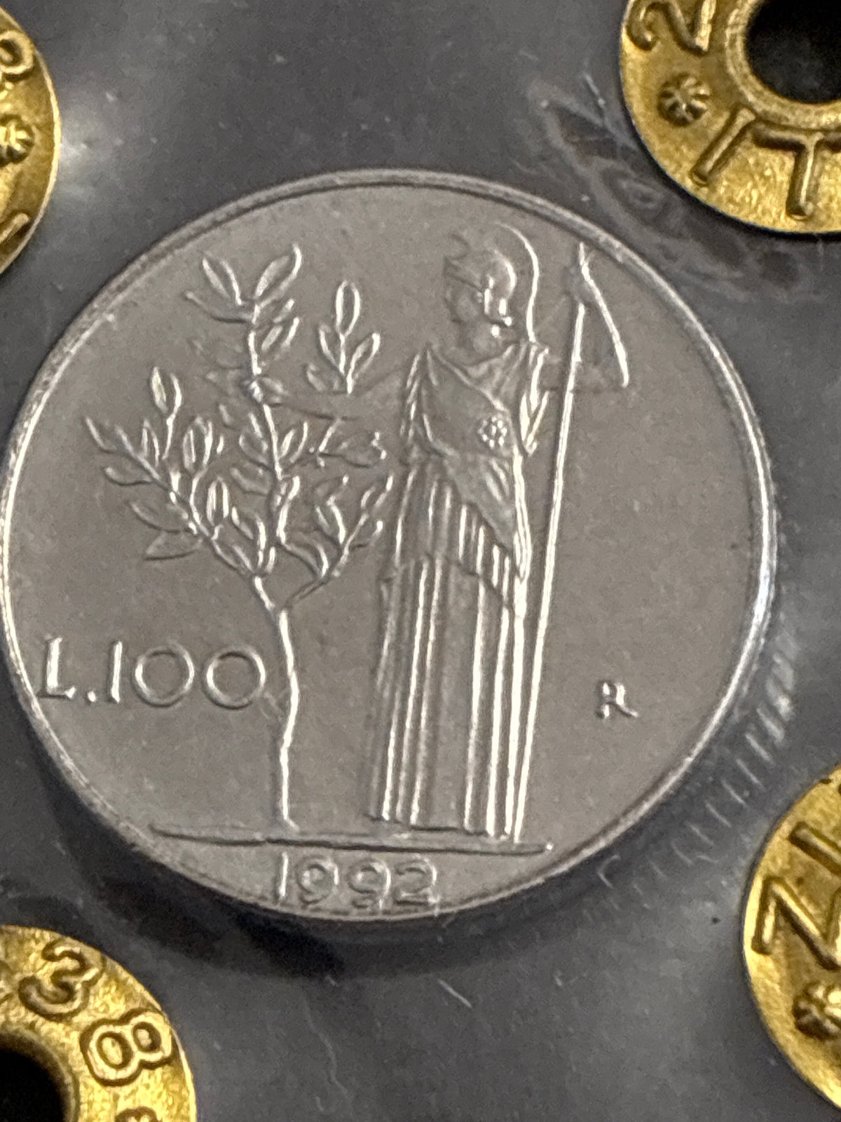 Moneta da 100 Lire 1992 Periziata Zilli - Errore di Conio: I Nr 99 Chiusi e Riga di Metallo in Rilievo Obliqua FDC
