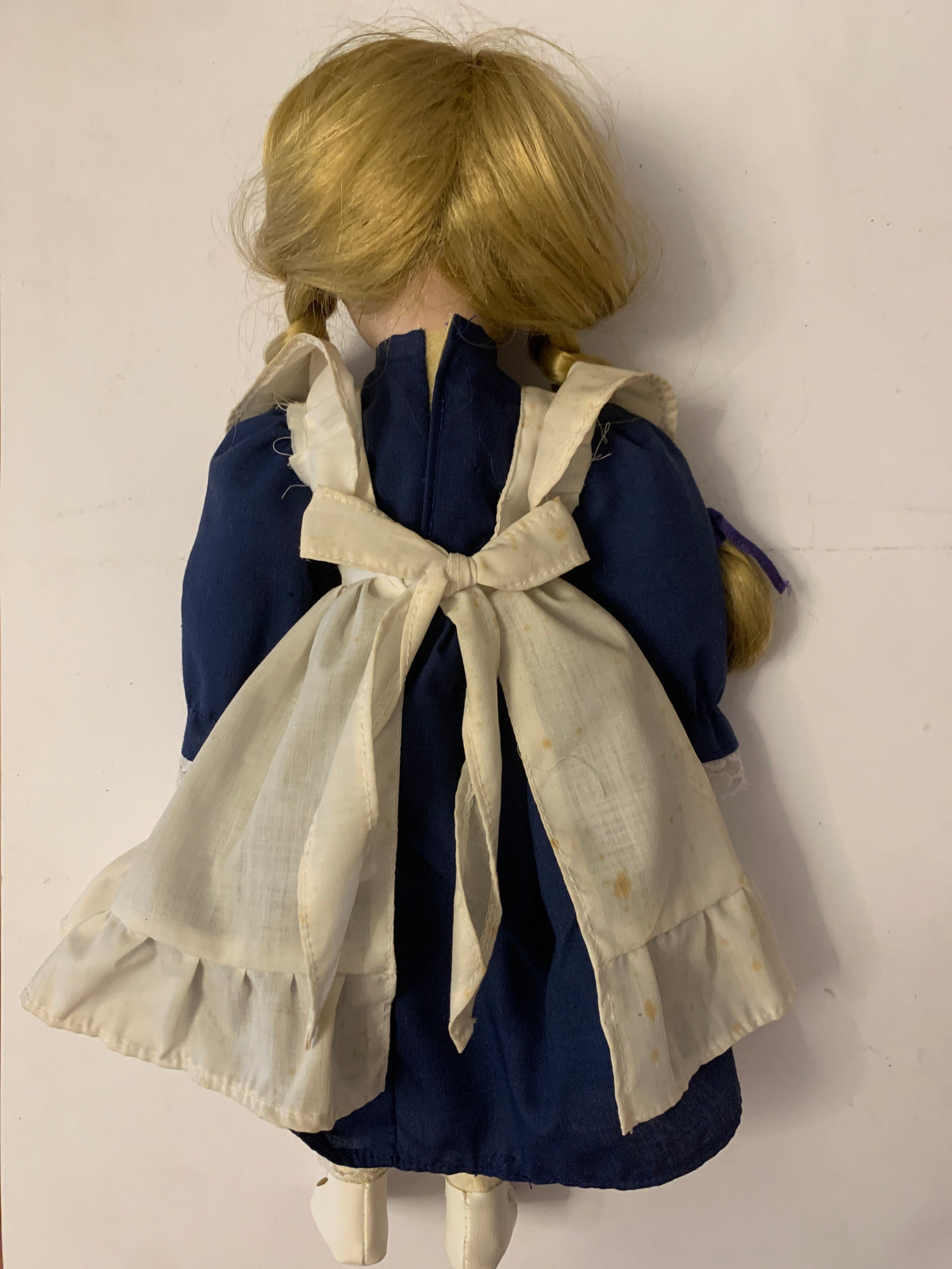 Bambola di porcellana vintage con trecce, occhiali e vestito blu con grembiule