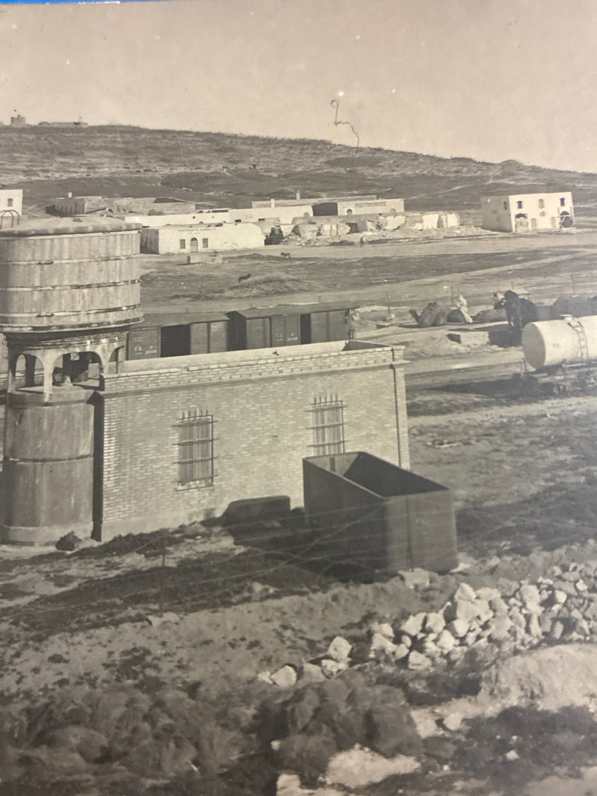 Cartolina postale italiana d'epoca coloniale con veduta dello scalo ferroviario e dei vagoni cisterna della ferrovia di Azizia in Libia
