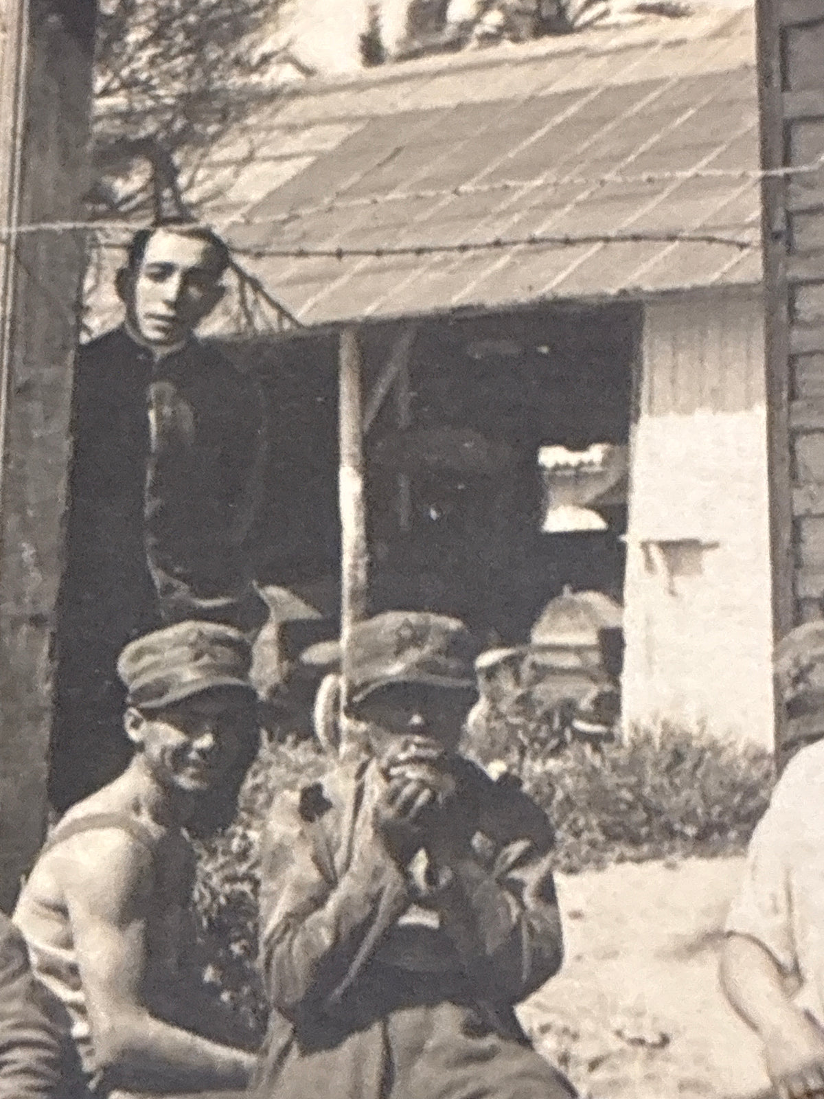 Cartolina postale italiana d'epoca coloniale con soldati e ufficiali del Regio Esercito in posa davanti a un baraccamento militare in legno.