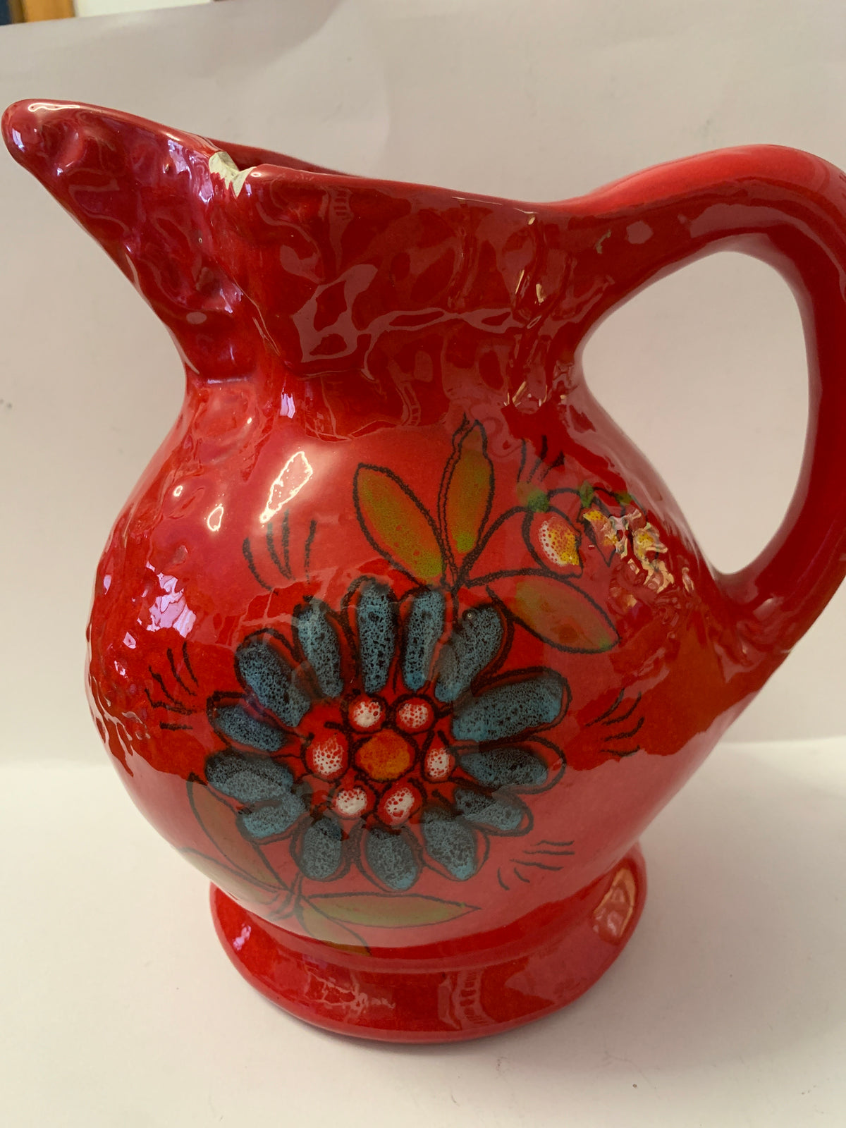 Brocca vintage in ceramica rossa con decoro floreale dipinto a mano.